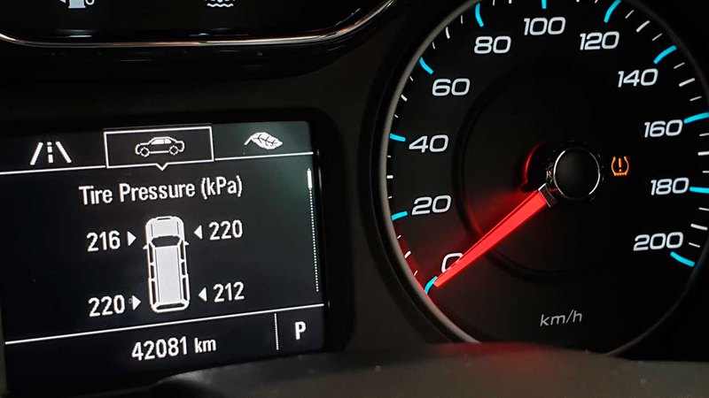 A car’s dashboard showing the average psi for car tires on an activated TPMS display monitor
