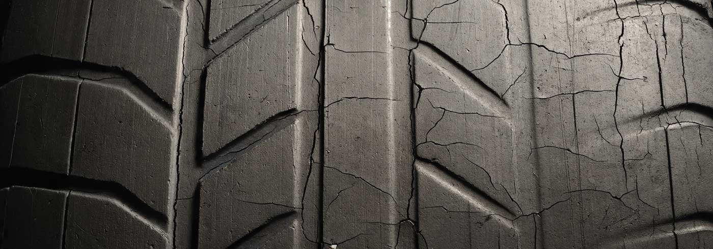 a closeup of tires wear on outside edge of a car wheel that needs to be fixed